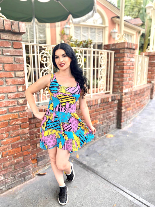 Our stunning model stands outside of the gates of the haunted mansion, holiday edition, wearing a fun colorful sally dress, inspired by the nightmare before Christmas.
