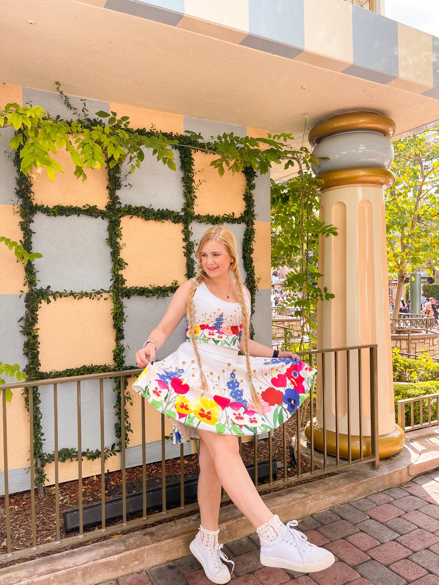 Our model wears a wonderland inspired ladies crop top outside of fantasyland at the famous Disneyland park. 