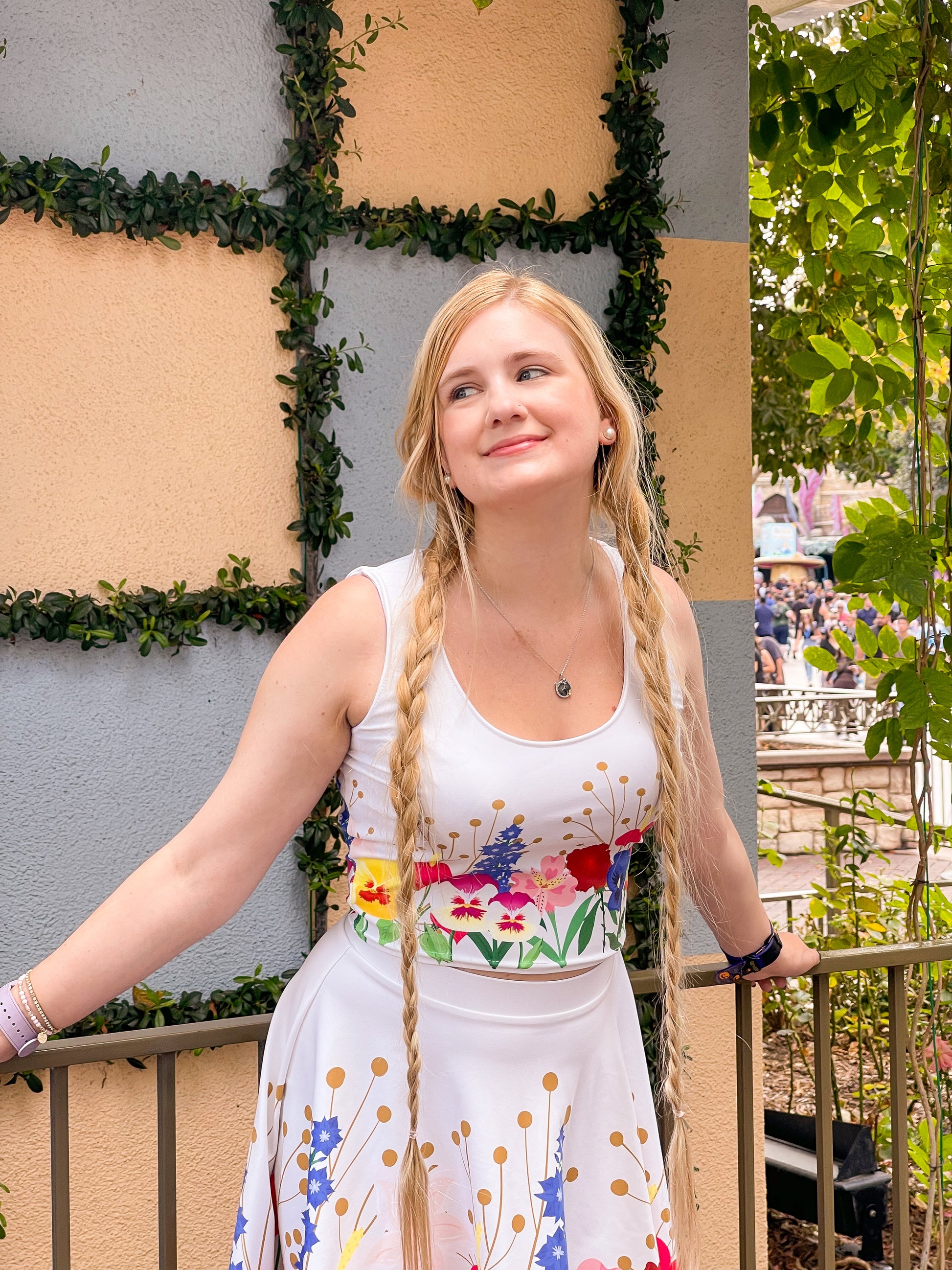 Our model wears a wonderland inspired ladies crop top outside of fantasyland at the famous Disneyland park. 