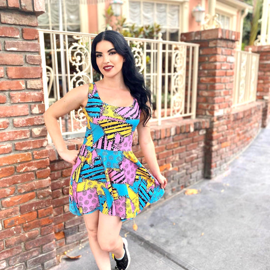 Our stunning model stands outside of the gates of the haunted mansion, holiday edition, wearing a fun colorful sally dress, inspired by the nightmare before Christmas.